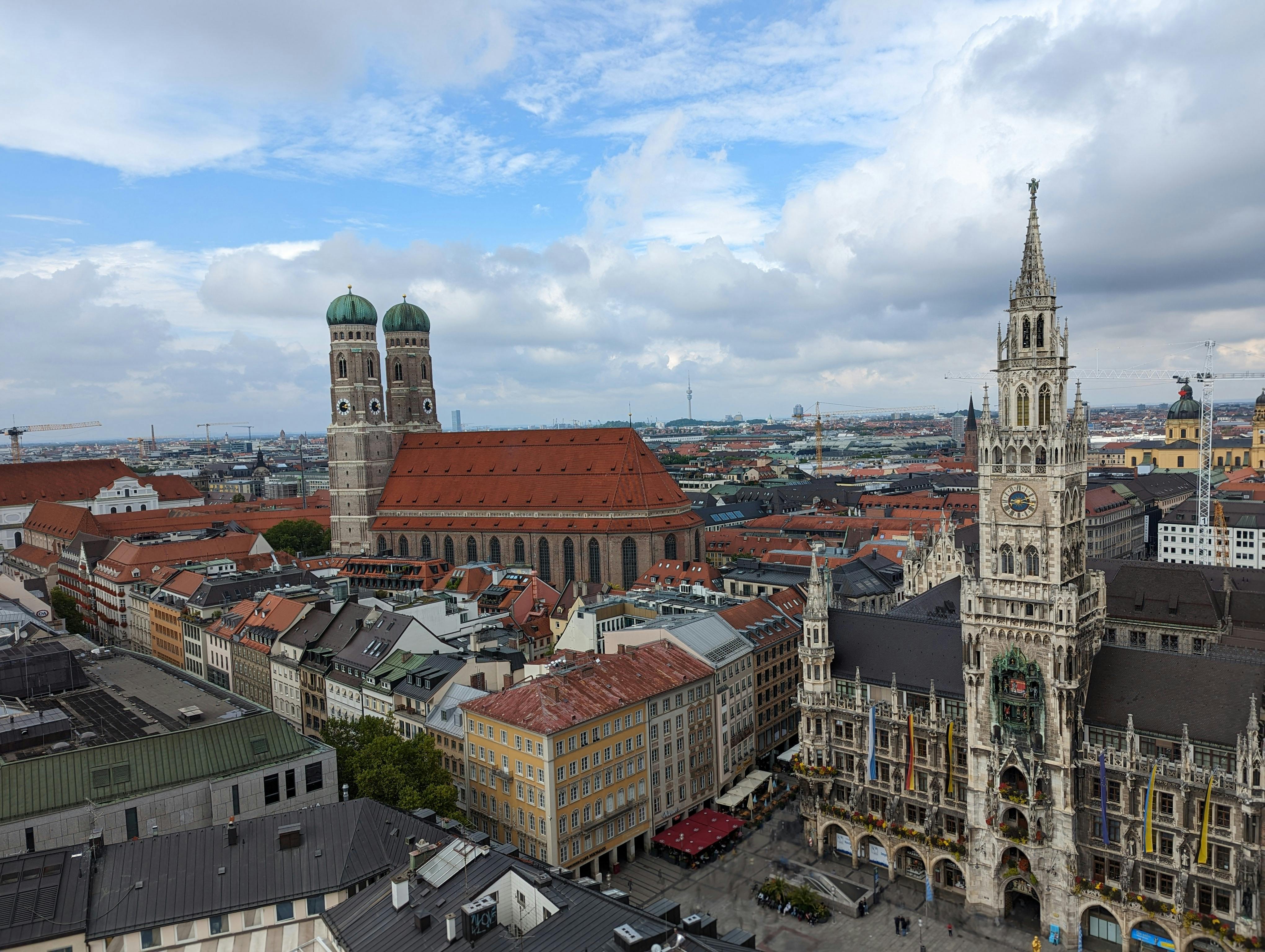 Stunning aerial view of Munich's Marienplatz with the New Town Hall and Frauenkirche under a vibrant sky.