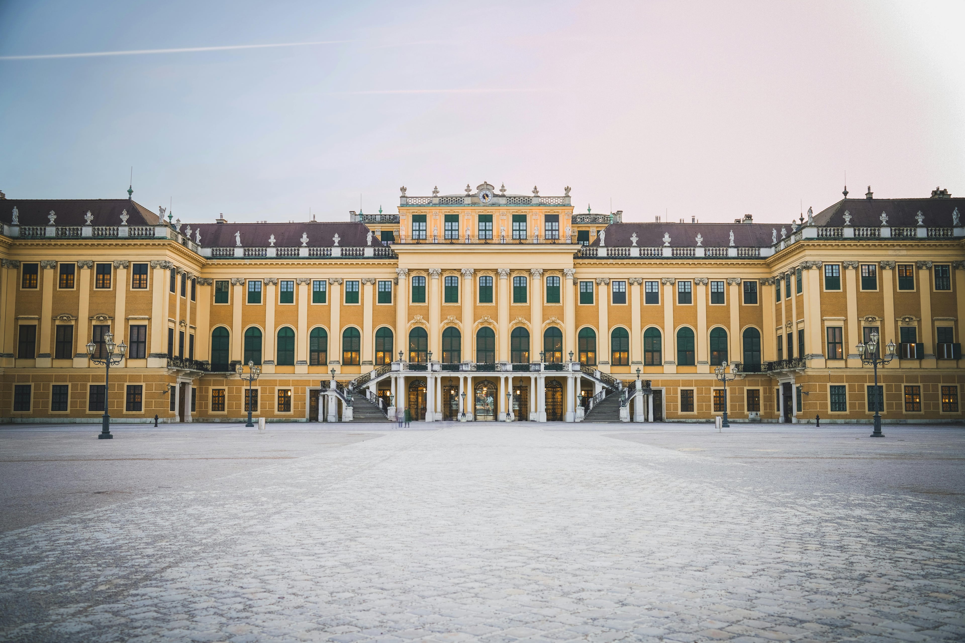 The grand baroque facade of Schoenbrunn Palace in Vienna, Austria during the day.