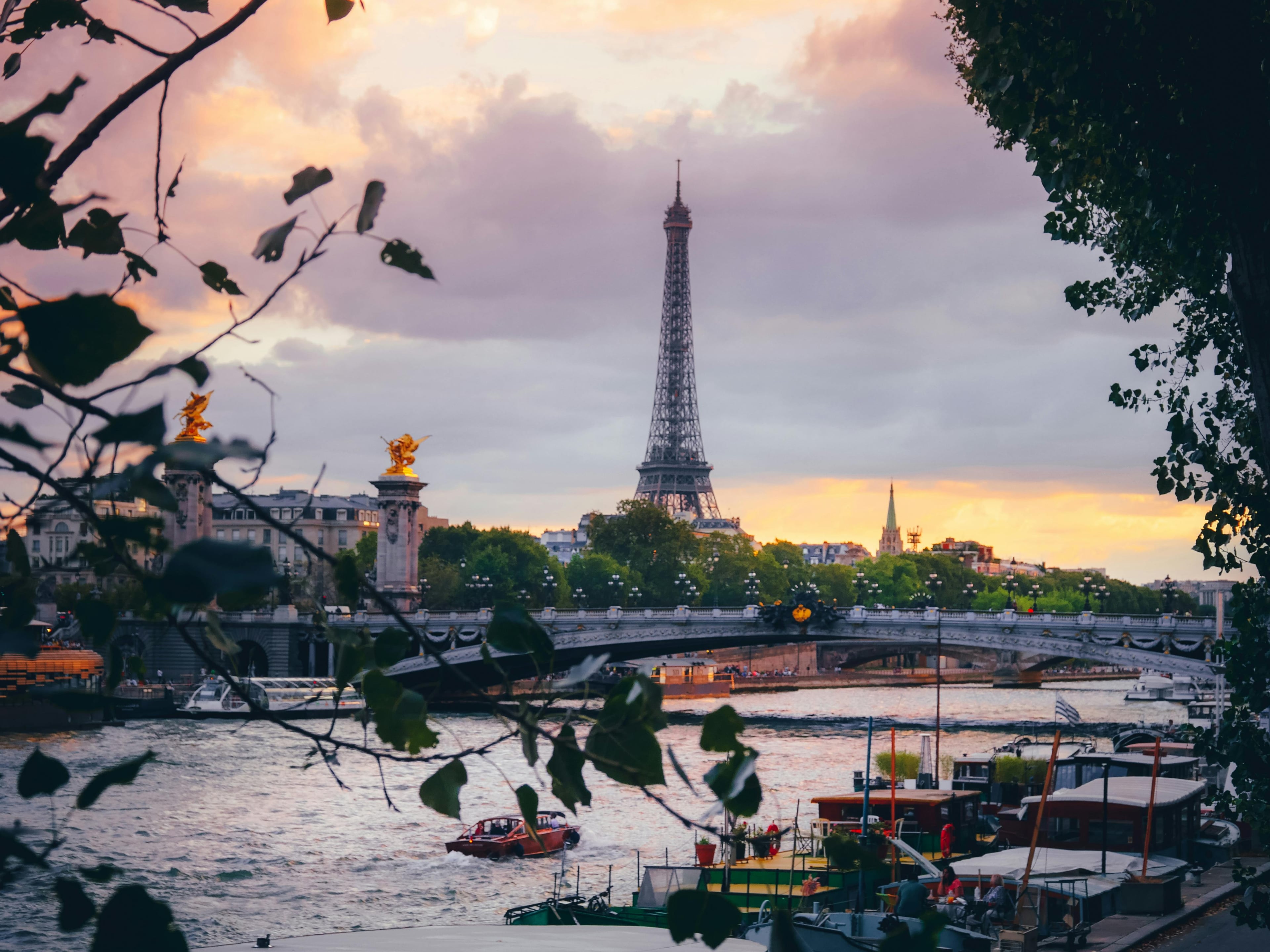 Beautiful sunset view of the Eiffel Tower over the Seine River in Paris, showcasing iconic French architecture.