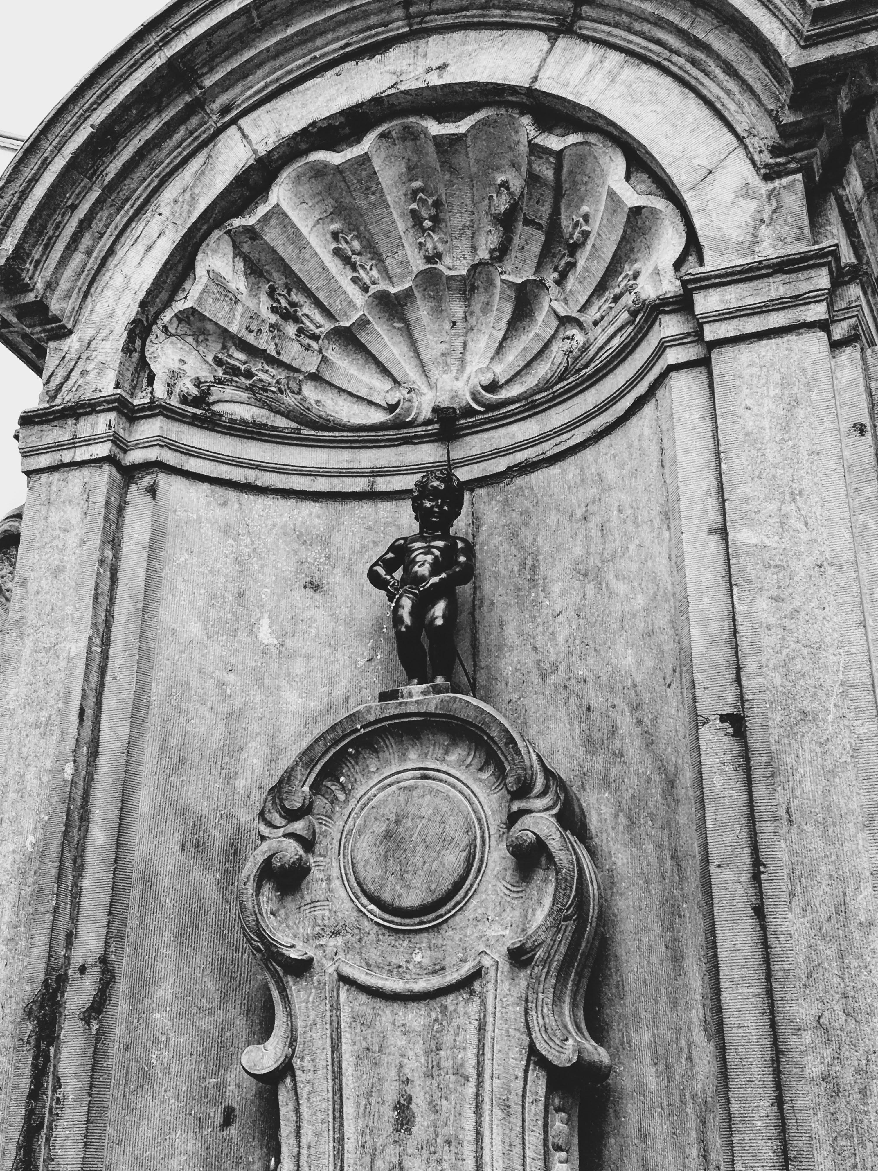 Grayscale image of the famous Manneken Pis statue in Brussels, Belgium.