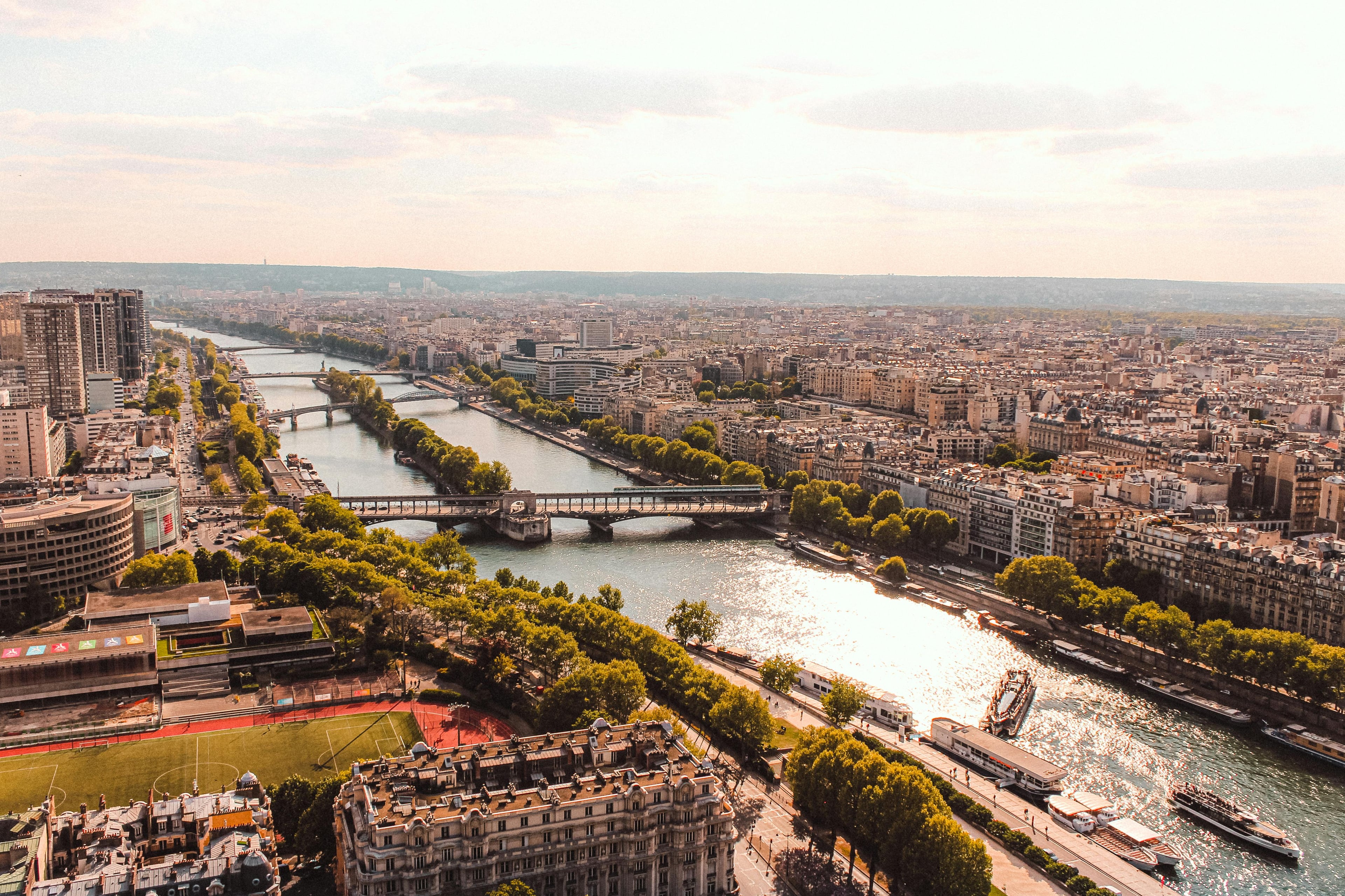 Drone view of calm river with bridges connecting parts of modern town in cloudy evening