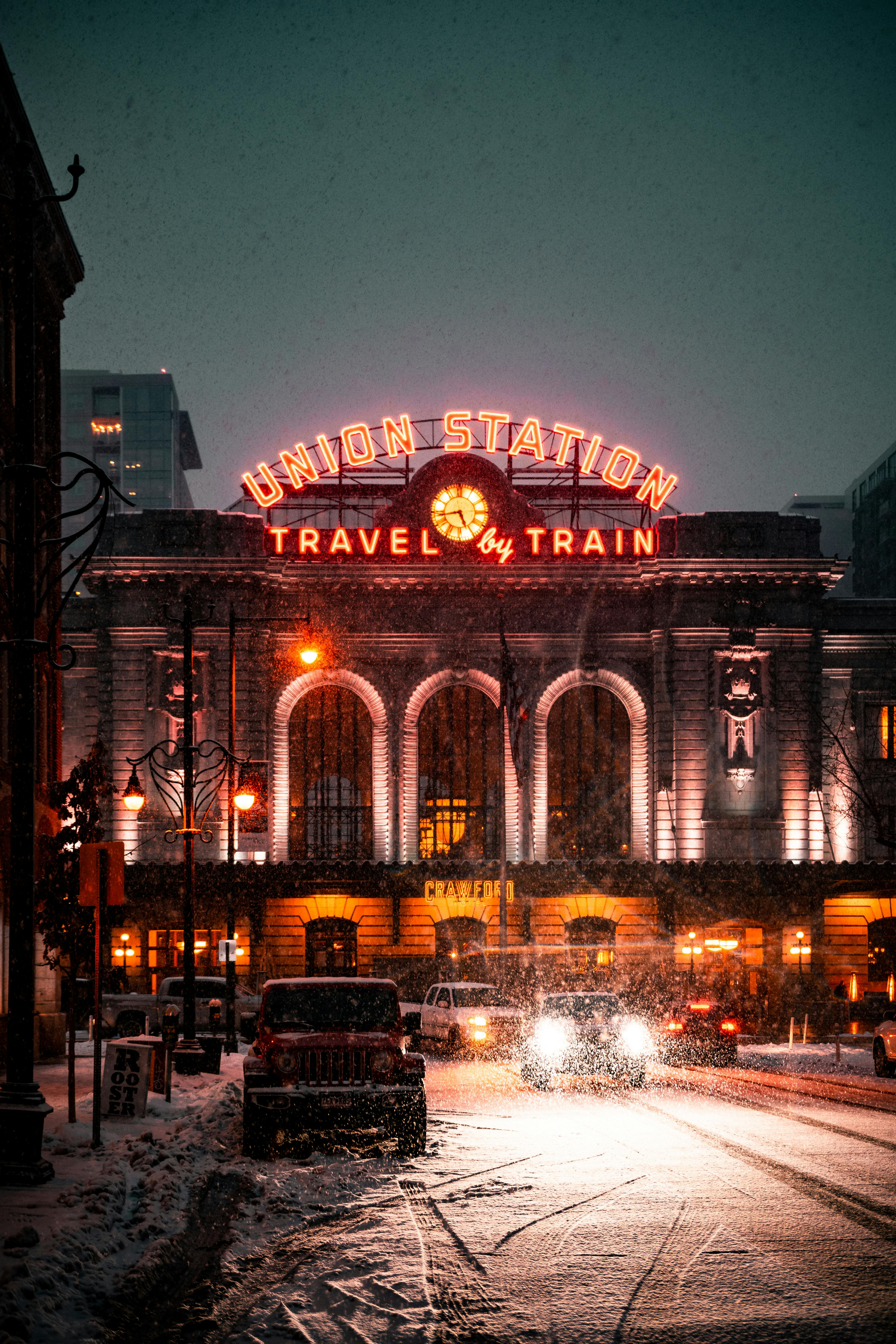 Illuminated Denver Union Station in snowfall, highlighting urban winter charm.