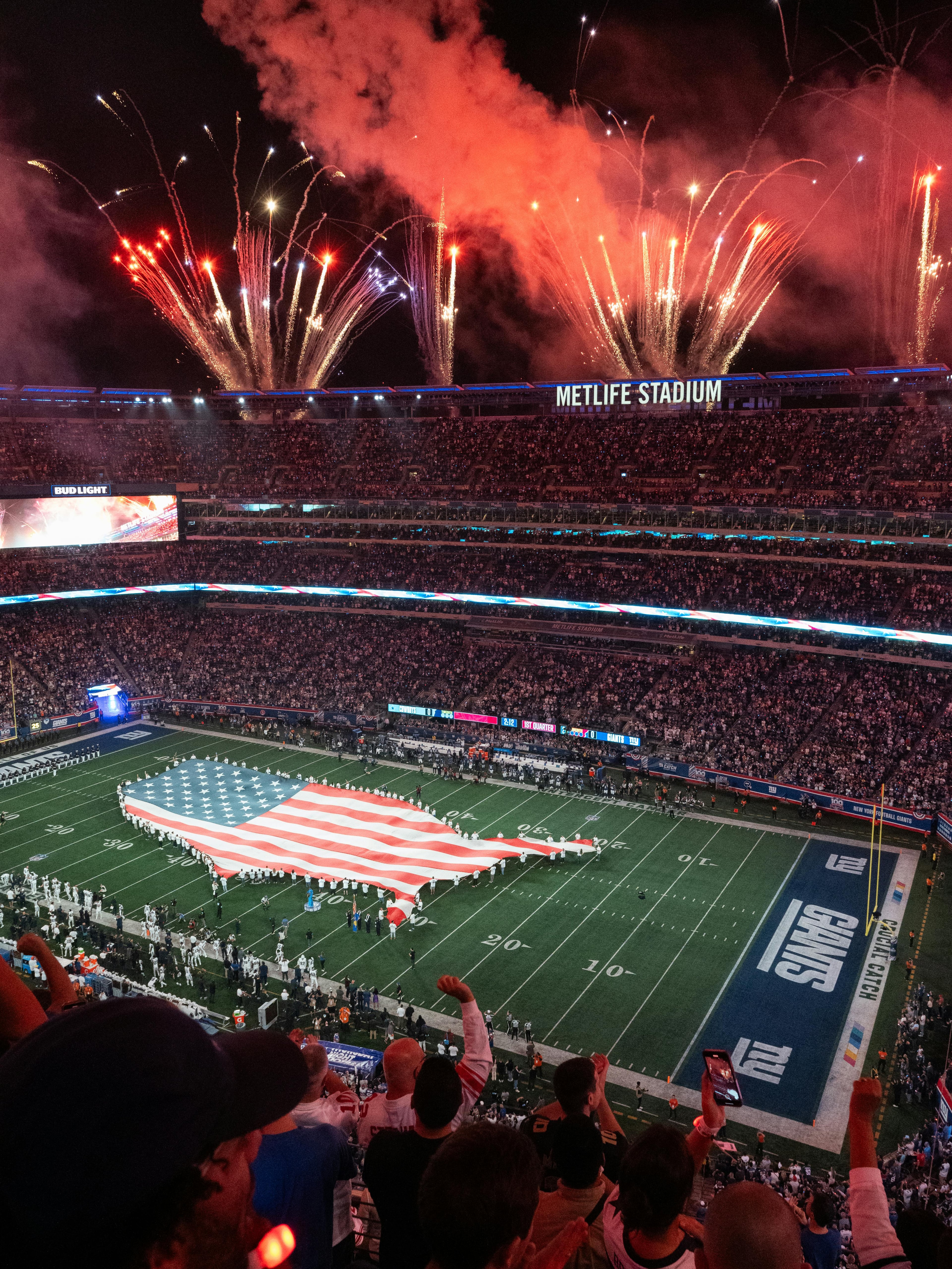 An exciting NFL match day at MetLife Stadium with fireworks and USA flag display.