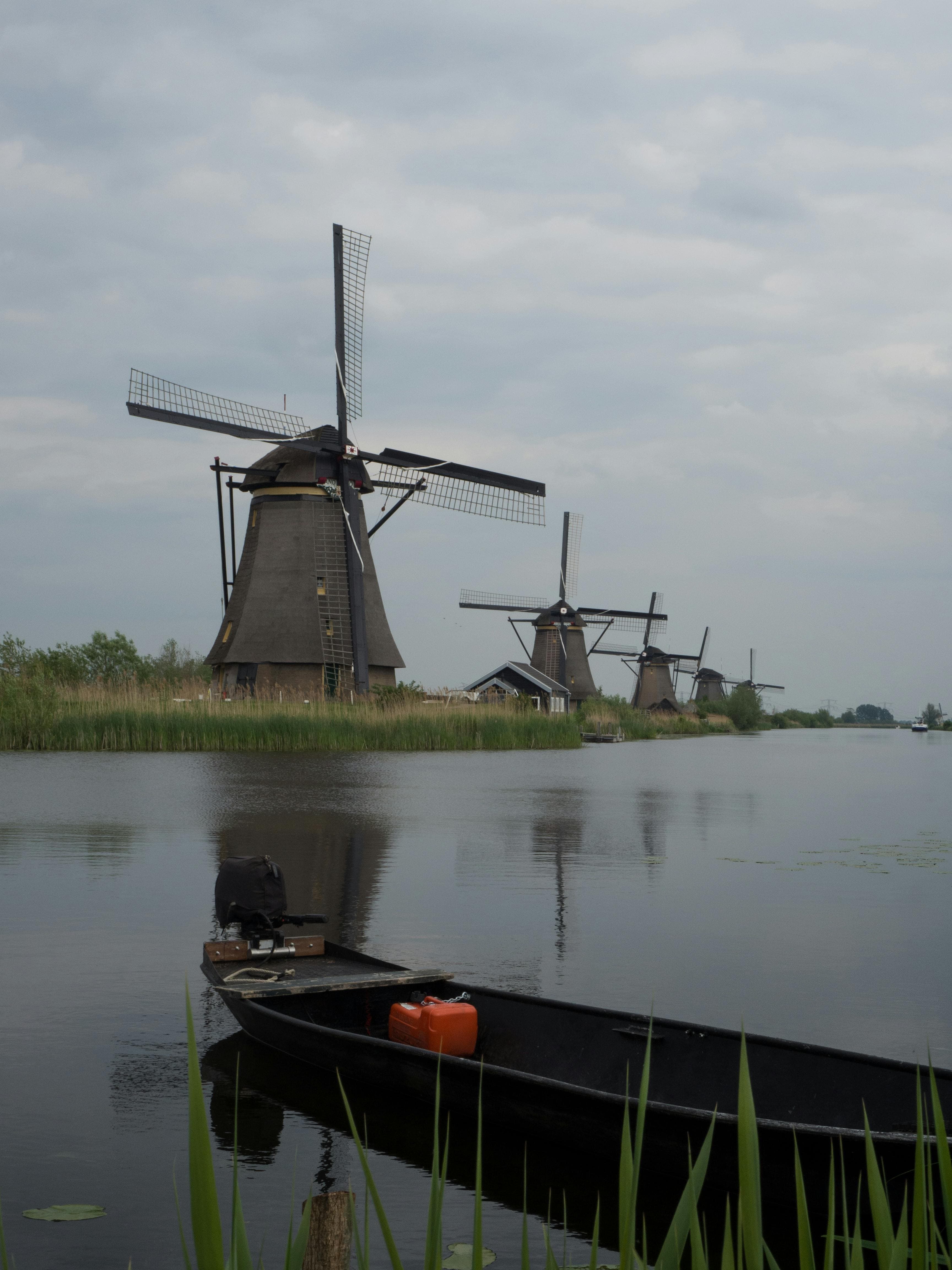 Traditional Dutch windmills by a serene lake in Kinderdijk, Netherlands, perfect for stock photography.