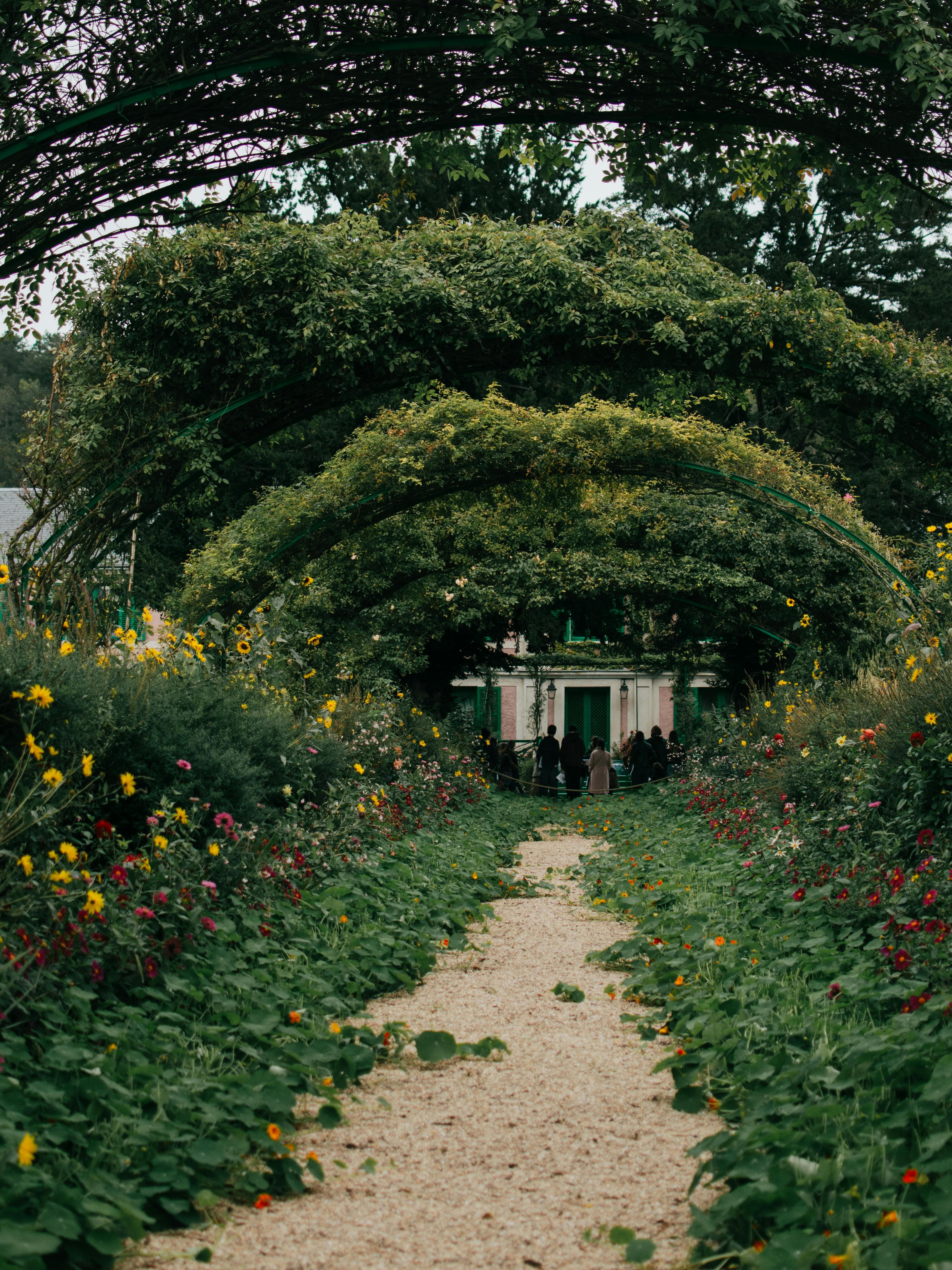 Captivating floral archway leading to Monet's house in Giverny, France.