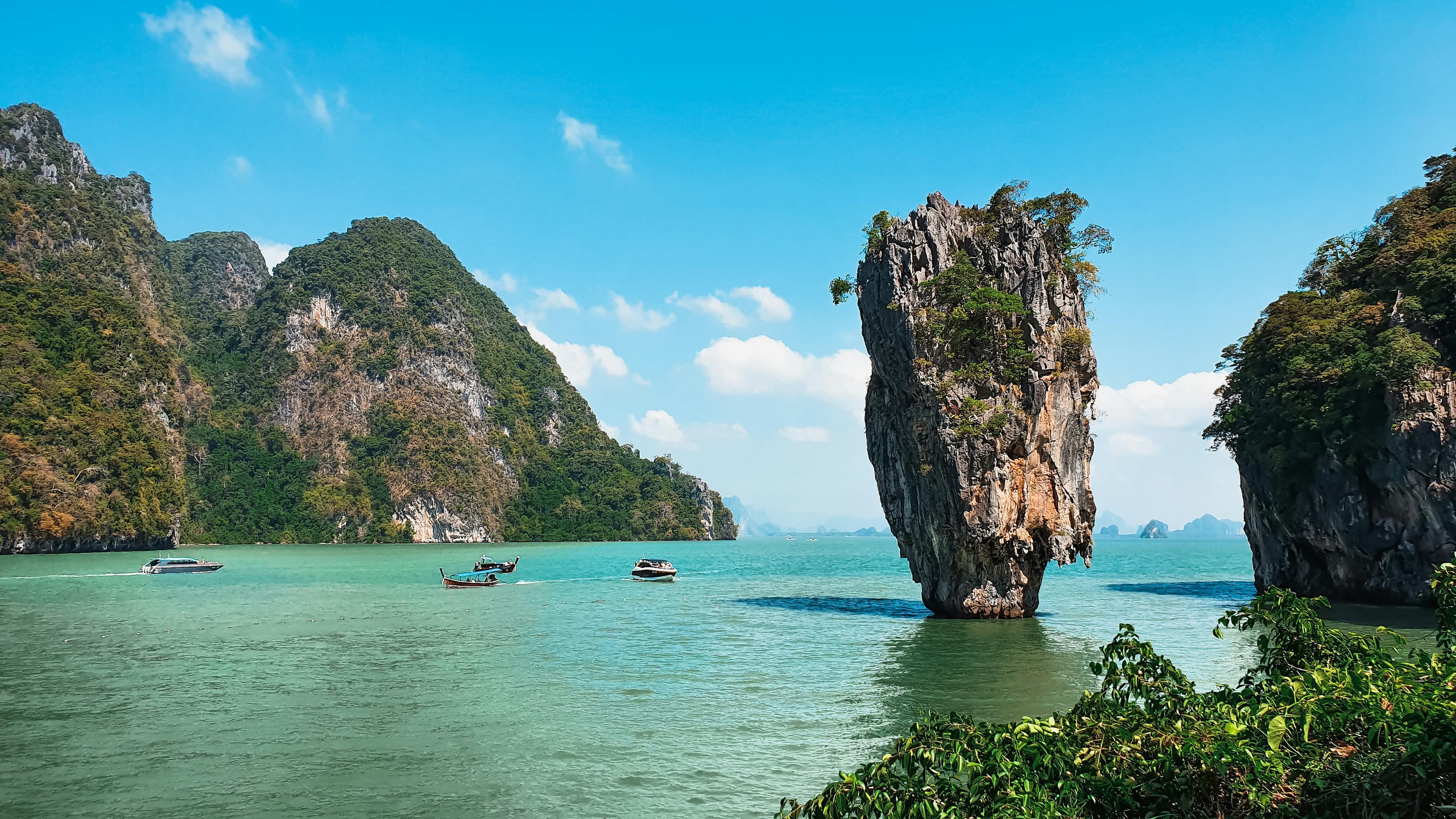 Scenic view of James Bond Island in Thailand with boats and turquoise water.